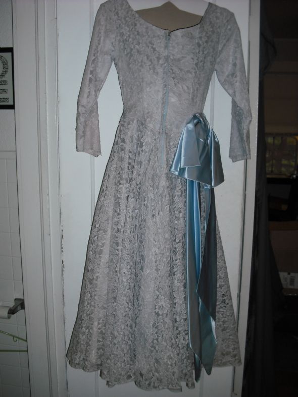 It has a light blue sash that is attached to the dress but could be moved or