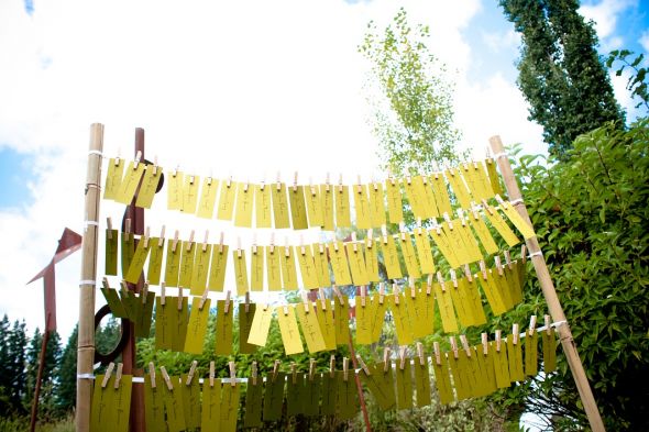 DIY Friday : wedding diy features Escort Cards 1 Escort Cards on ribbon, rows strung between two bamboo poles outdoors : wedding escort cards name cards tables green white inspiration diy reception Escort Cards 1