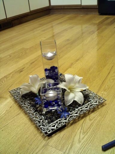 The vases are filled with blue and silver beads then water and a floating