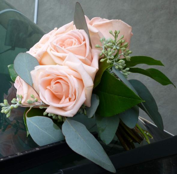 Rose arm bouquet with peach roses snowberry seeded eucalyptus and plumsous 