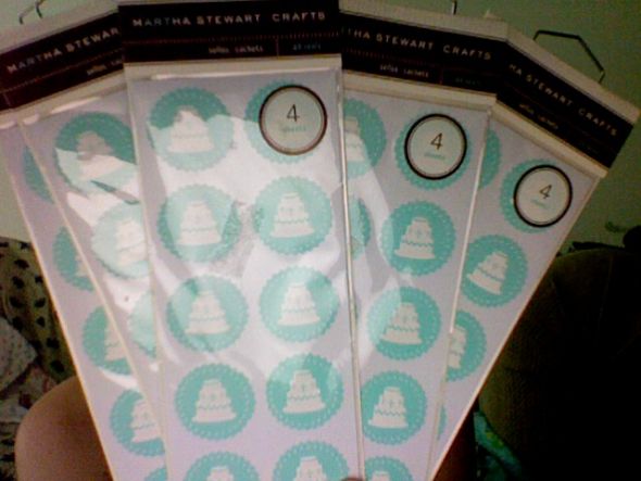 Five sealed packages of Martha Stewart Embossed Wedding Cake Seals
